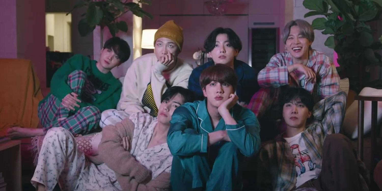BTS in the Life Goes On music video, dressed in pajamas in a cozy living room setting
