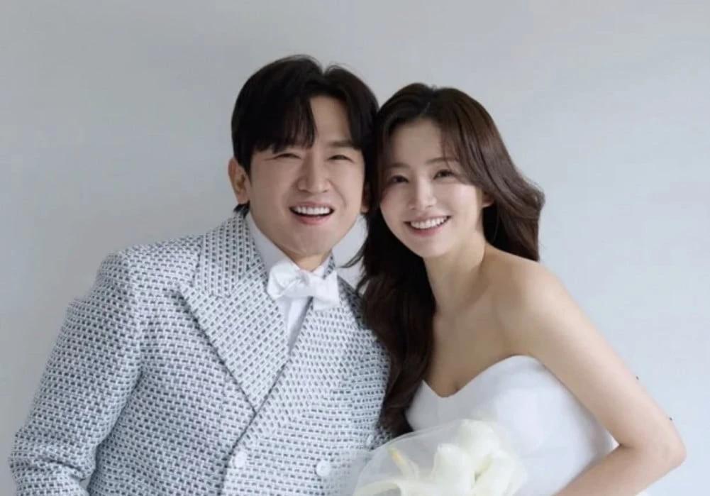 Lee Min Woo and Lee Ah Mi wedding pictorial in color, man in gray suit with bow tie and woman in white dress holding calla lilies