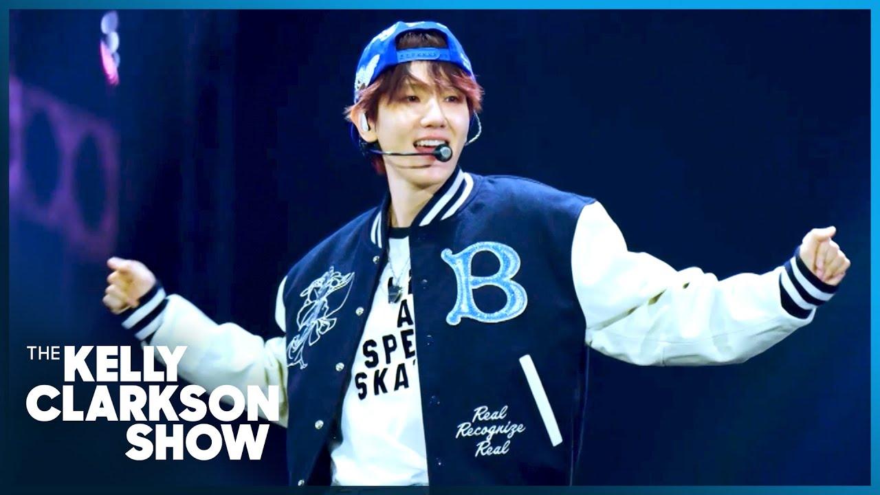 Baekhyun performing Magic On The Floor on The Kelly Clarkson Show, wearing a navy varsity jacket with the show logo visible
