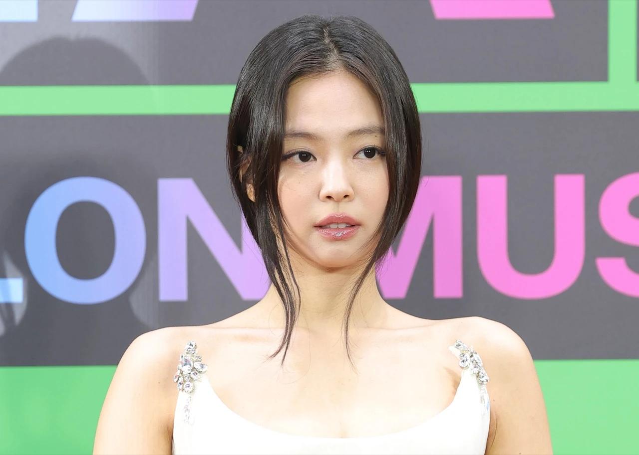 Jennie at a public event in a white embellished dress, used for HITKULTR coverage of her OA Entertainment earnings