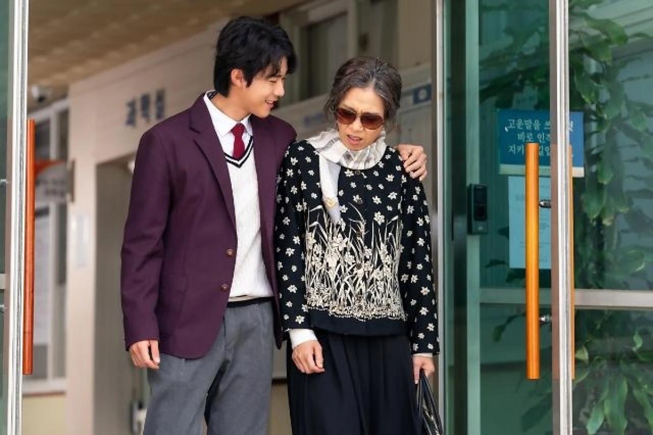 A still from the Korean film My Name showing two characters walking out of a doorway together.