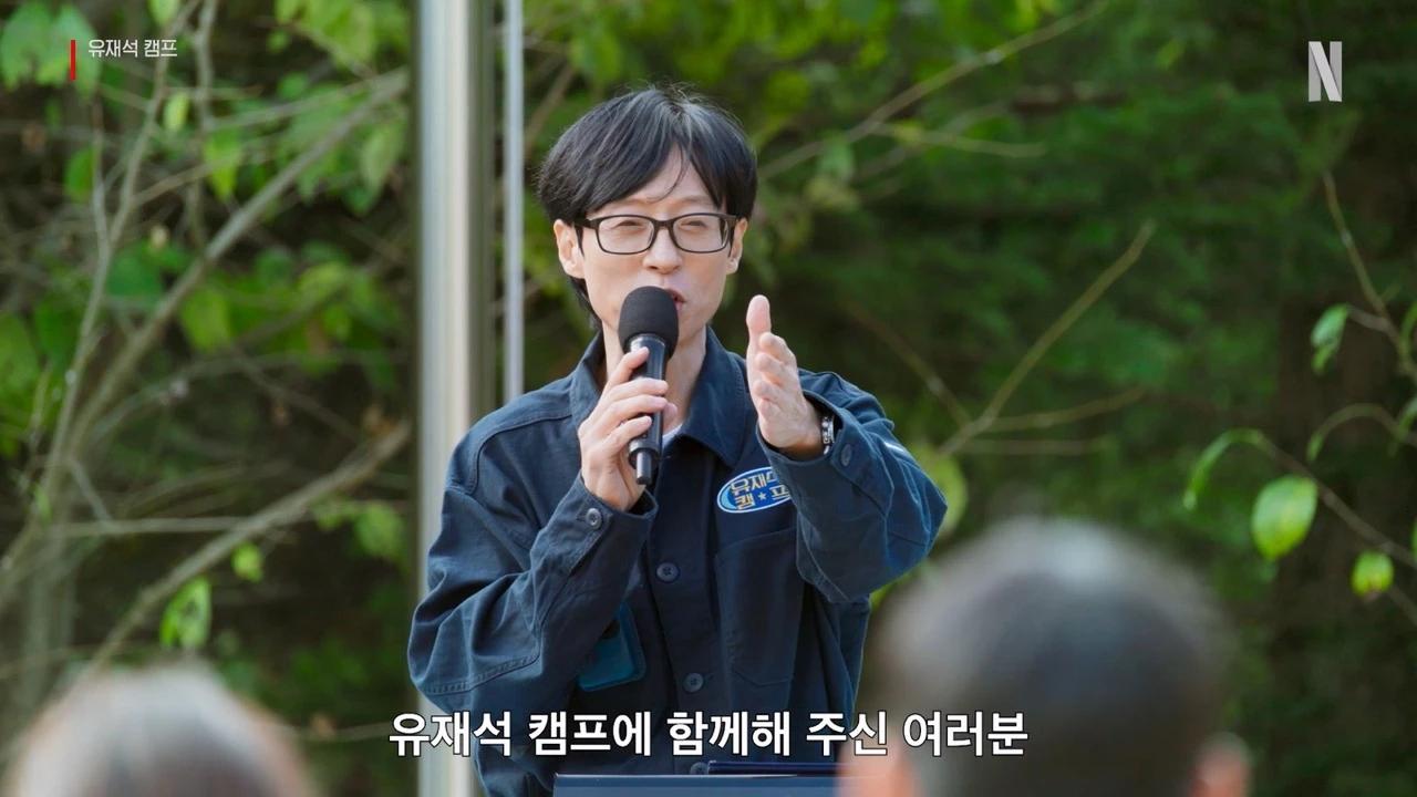 Yoo Jae-seok speaking to campers in a still from Netflix's Jae-seok's B&B Rules