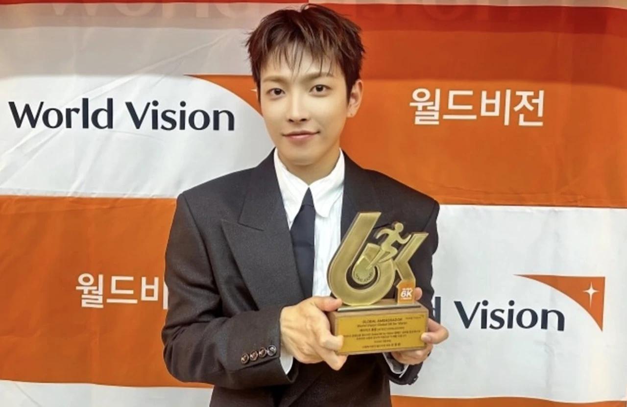 Hongjoong of ATEEZ holding the Global Ambassador trophy at World Vision headquarters in Seoul, March 26 2026. Photo: KQ Entertainment