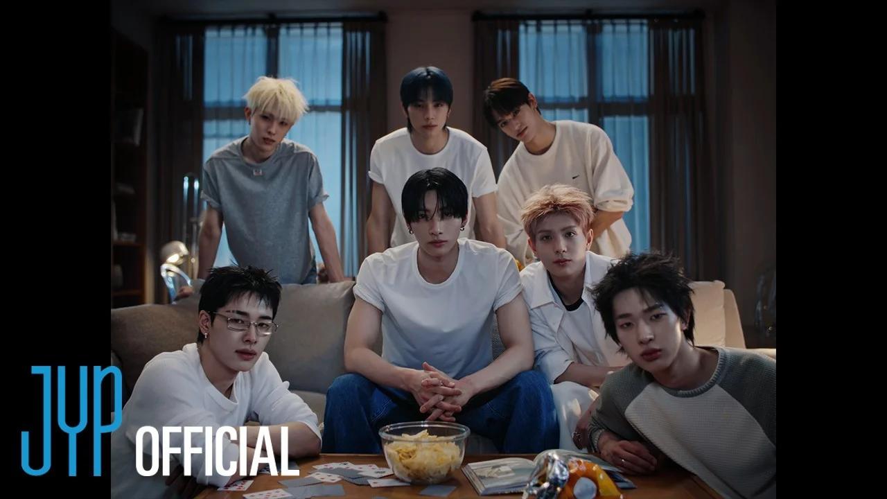 NEXZ members gathered in a living room setting in the official JYP trailer image for Mmchk